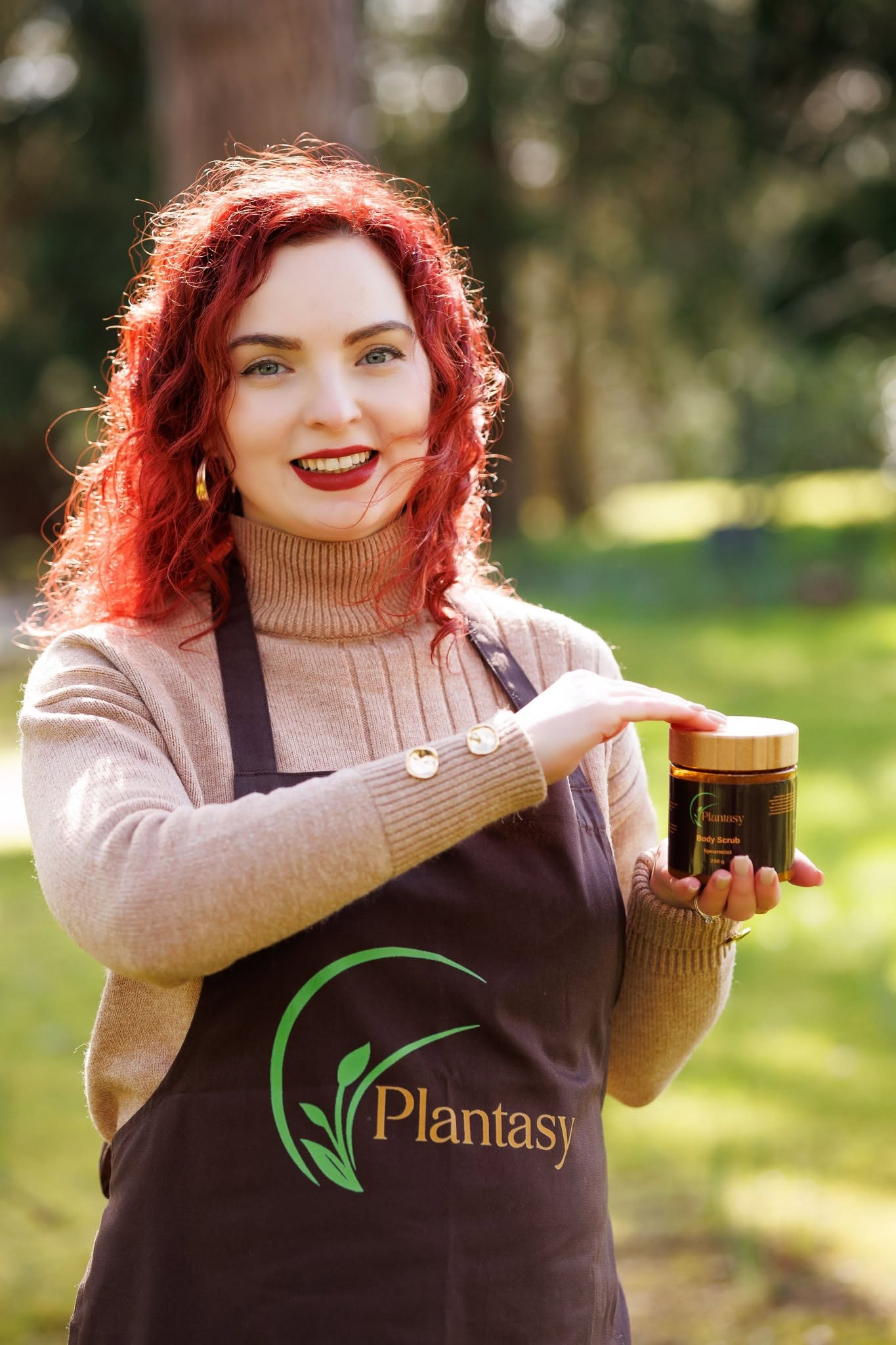 Diana, Plantasy founder and formulator, holding a body scrub outdoors